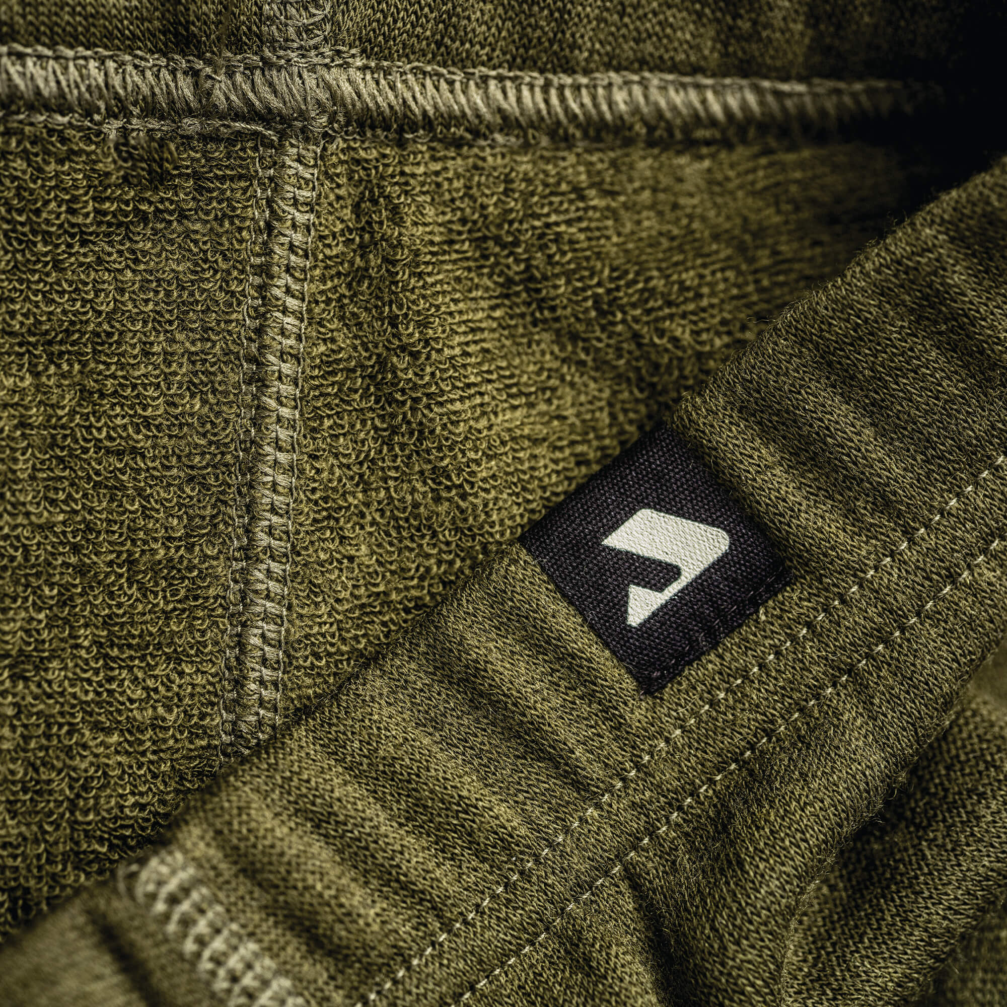 Close-up of green leggings in merino with Janus Wool logo on the waistband.