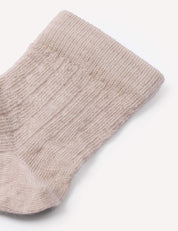 A close-up of the top portion of the beige, ribbed knit Socks – Merino Baby Light against a plain white background highlights these breathable baby socks.