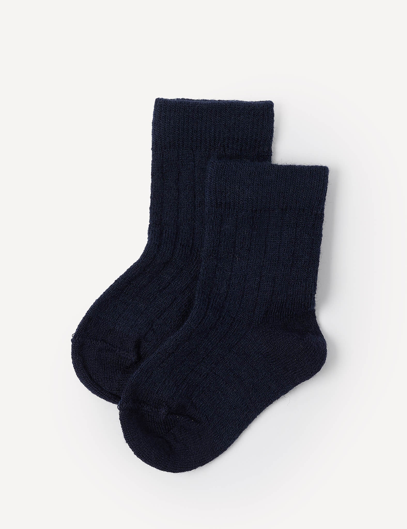 Two navy Merino Baby Light socks are laid flat on a plain white background, with one sock slightly overlapping the other. These ribbed crew socks are specially designed to provide comfort and long-lasting wear for children.