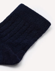 Close-up of the upper portion of a navy blue knit sock, showing its ribbed texture and cuff on a plain white background. This image showcases the design characteristic of the Socks – Merino Baby Light.