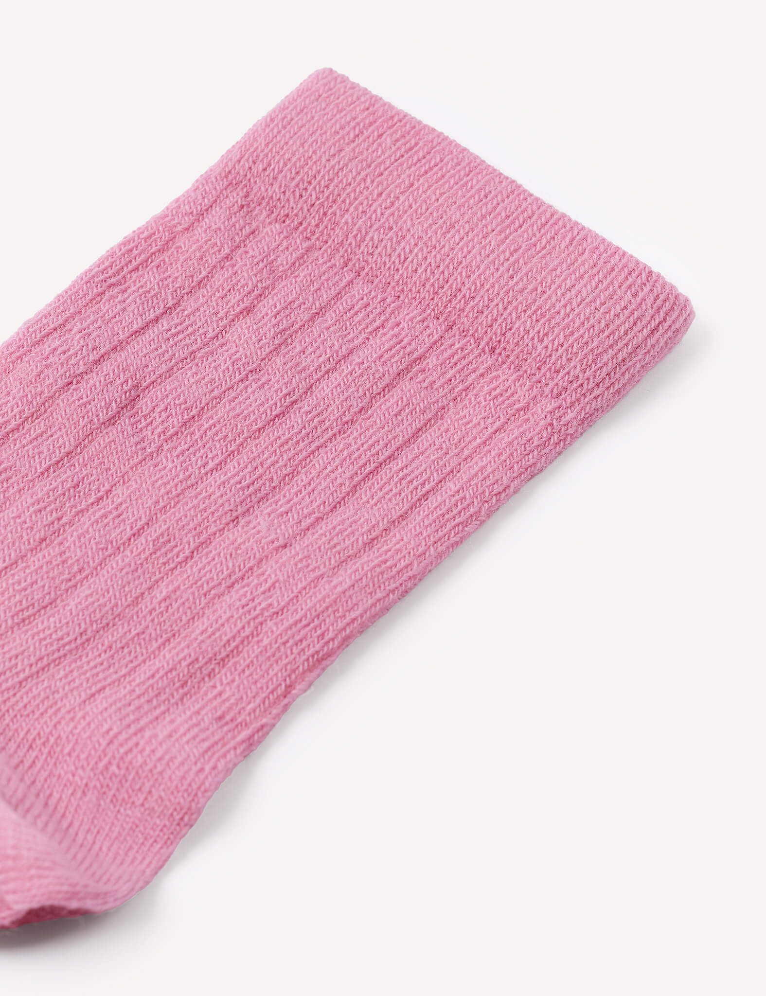 A close-up of the top part of a pink, ribbed knit Daily Socks – Merino Kids sock, photographed against a white background.