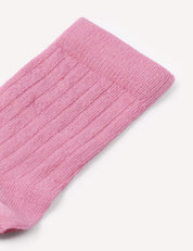 A close-up of the top part of a pink, ribbed knit Daily Socks – Merino Kids sock, photographed against a white background.