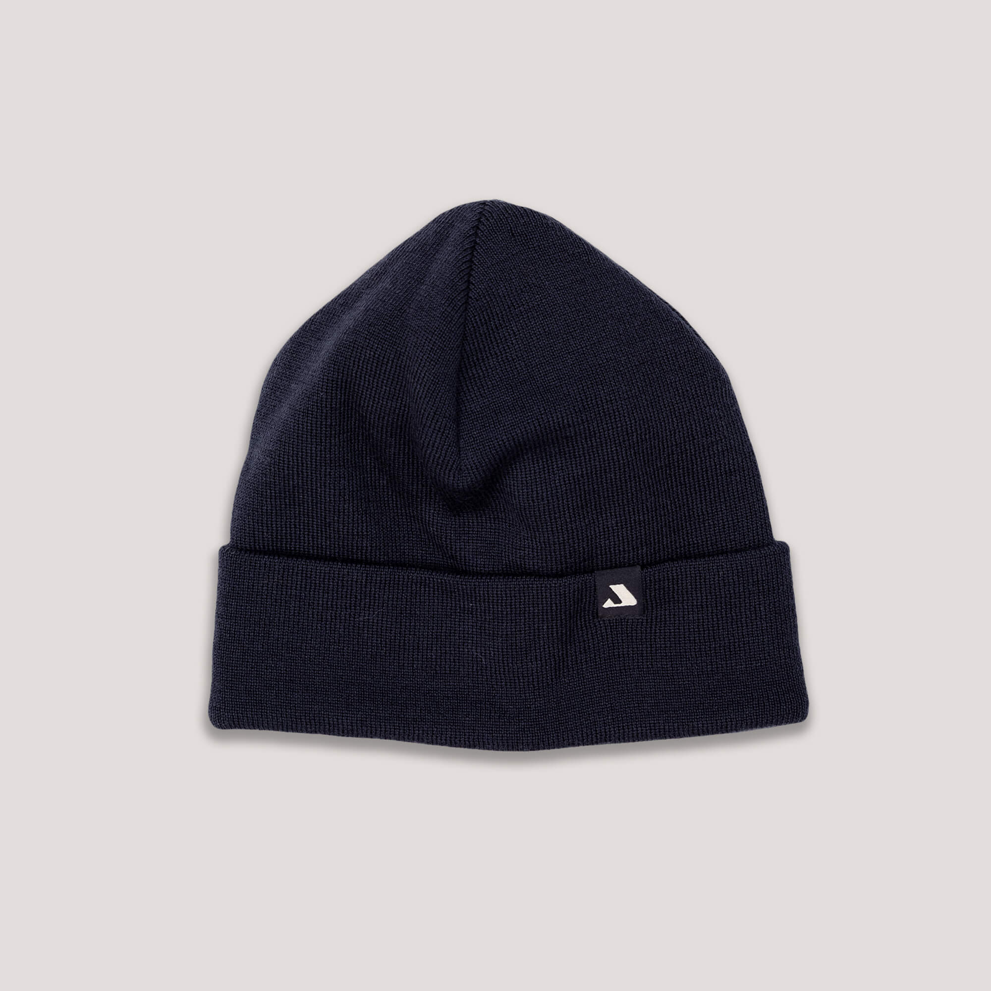 The navy MeshWool Beanie features a folded brim and a small rectangular tag with a white logo, shown on a light gray background. This warm beanie offers both style and breathability.