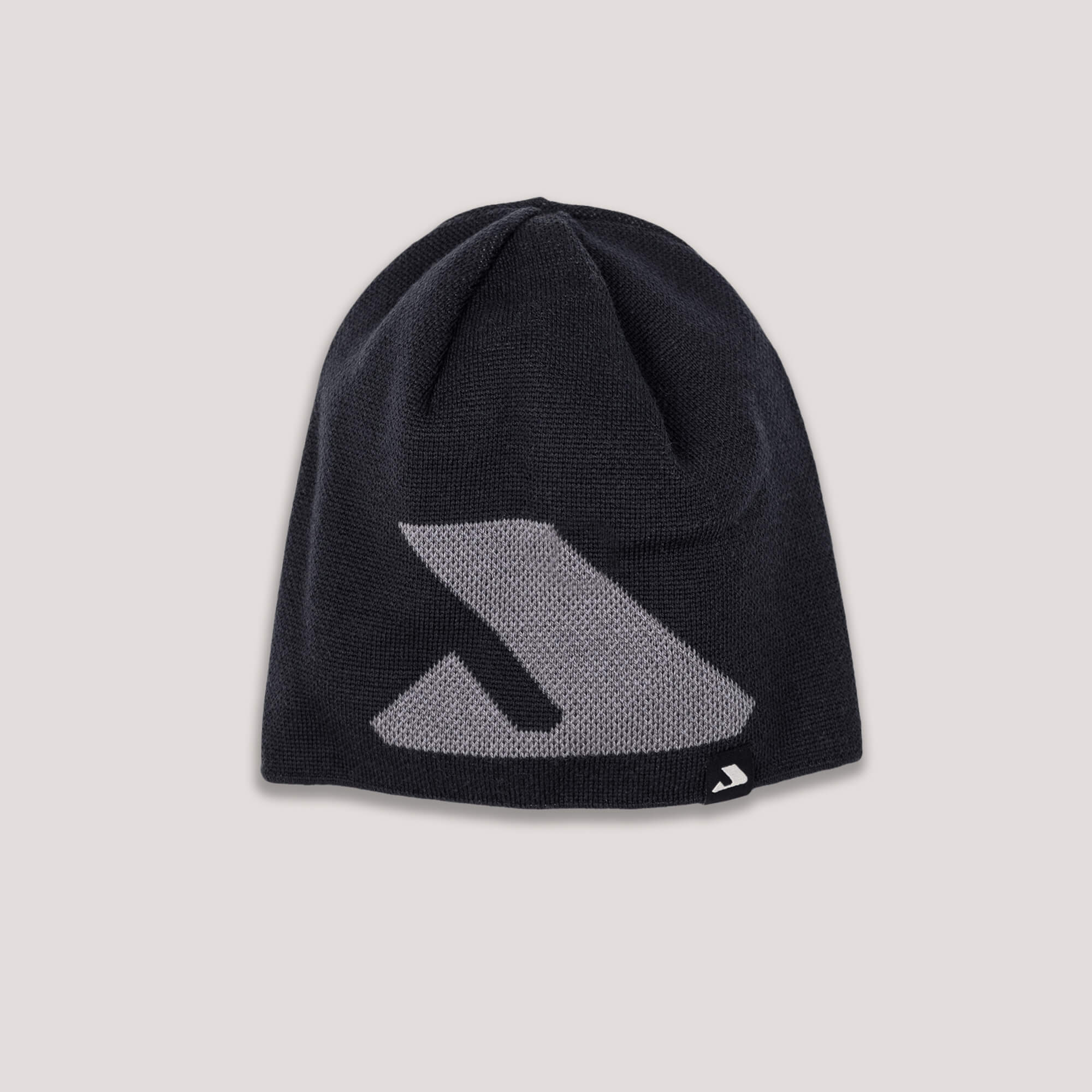 The Beanie – Logo in black is crafted from merino wool, featuring a large gray geometric logo on the front and a small matching tag at the edge for warmth and breathability. Shown on a light gray background.