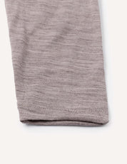 Close-up of the hem of a light gray, soft knit fabric pant leg from the Leggings – Merino Baby Light, laid flat on a white background.