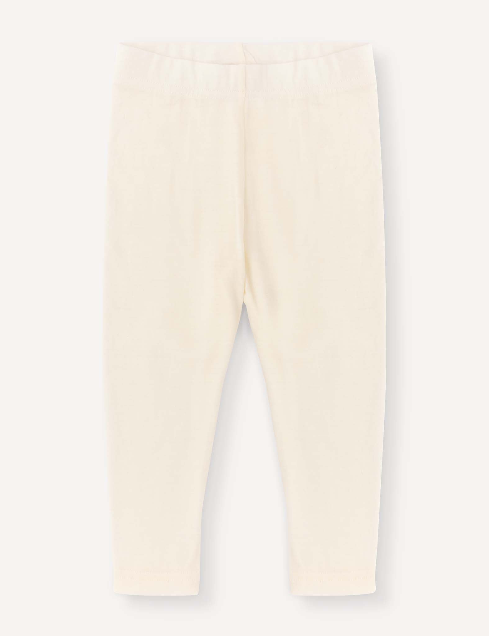 Marshmallow-colored Merino Baby Light leggings for babies or toddlers, featuring a lightweight fabric and an elastic waistband. Displayed flat on a plain light background, these leggings have a simple, minimalist design with no visible patterns or embellishments.