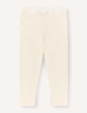 The Leggings – Merino Baby Light are cream-colored, full-length baby leggings shown flat on a light background, designed with an elastic waistband and no visible patterns or designs. These lightweight leggings provide a comfortable base layer for your little one.