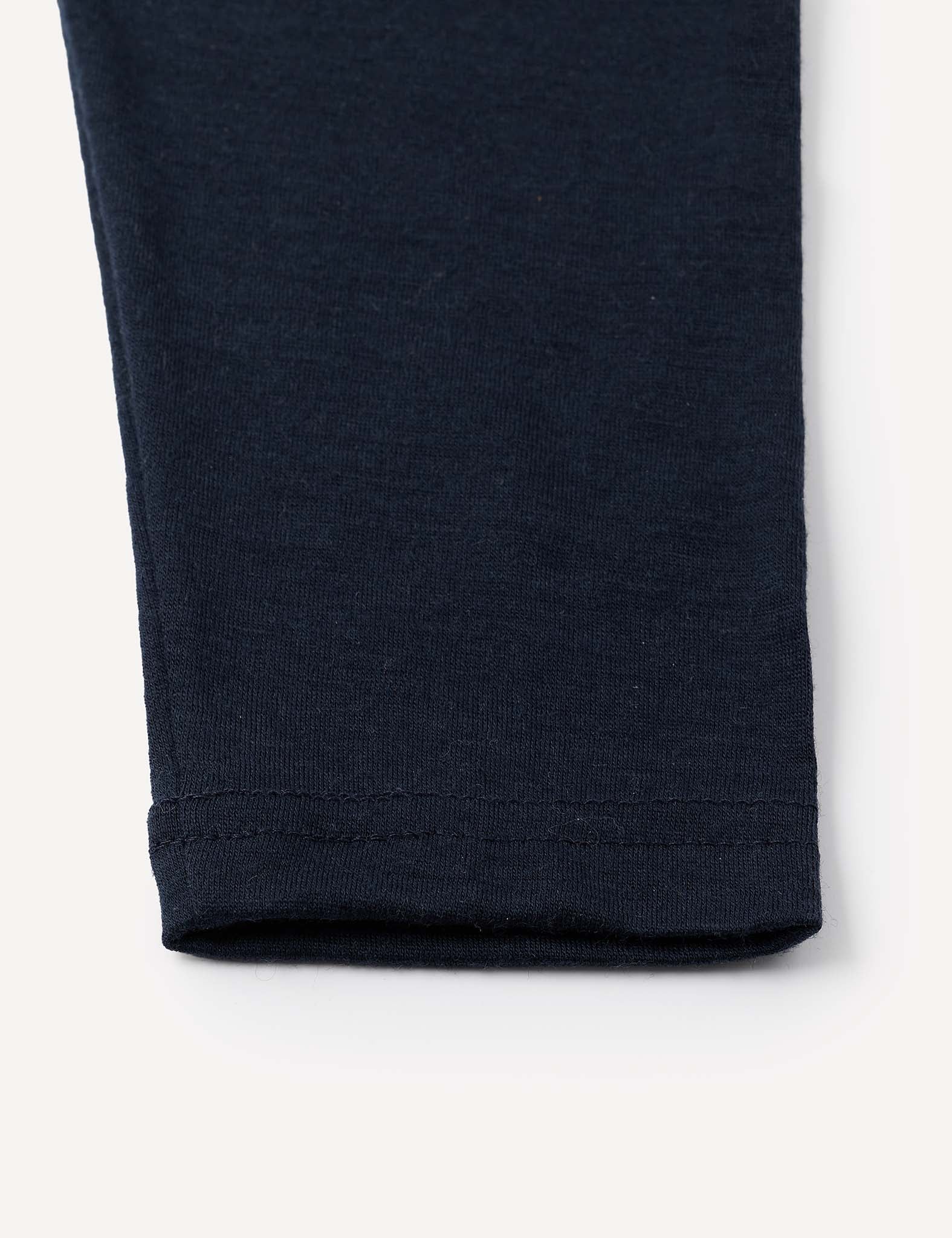 A close-up of the hem of the Leggings – Merino Baby Light, crafted from a soft, stretchy navy blue fabric—ideal for lightweight leggings or as a comfortable base layer—shown against a white background.