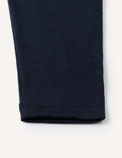 A close-up of the hem of the Leggings – Merino Baby Light, crafted from a soft, stretchy navy blue fabric—ideal for lightweight leggings or as a comfortable base layer—shown against a white background.