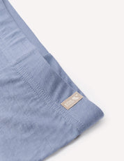 A close-up of the Leggings – Merino Baby Light in light blue fabric shows a visible seam and a small beige tag, making them ideal as a lightweight base layer or for breathable comfort.