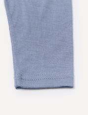 Close-up of the hem of a light blue Merino Baby Light legging, highlighting precise stitching details on a plain white background—perfect as a lightweight base layer or paired with breathable leggings.