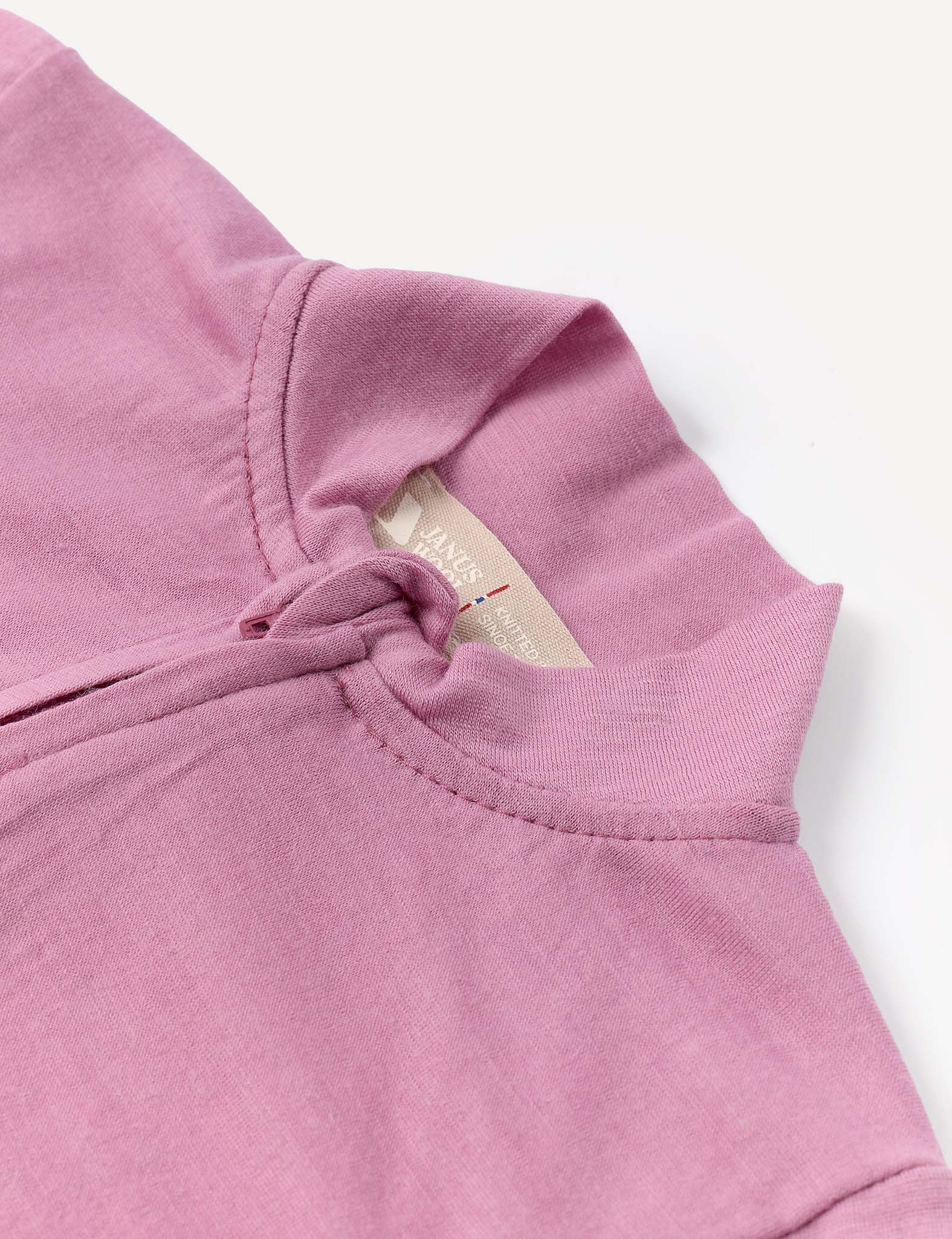 A close-up of the Pyjamas – Merino Baby Light in light purple, featuring a fabric knot at the neckline and a beige tag with text inside the collar. Crafted from breathable pyjamas material, the shirt is laid flat on a white background.