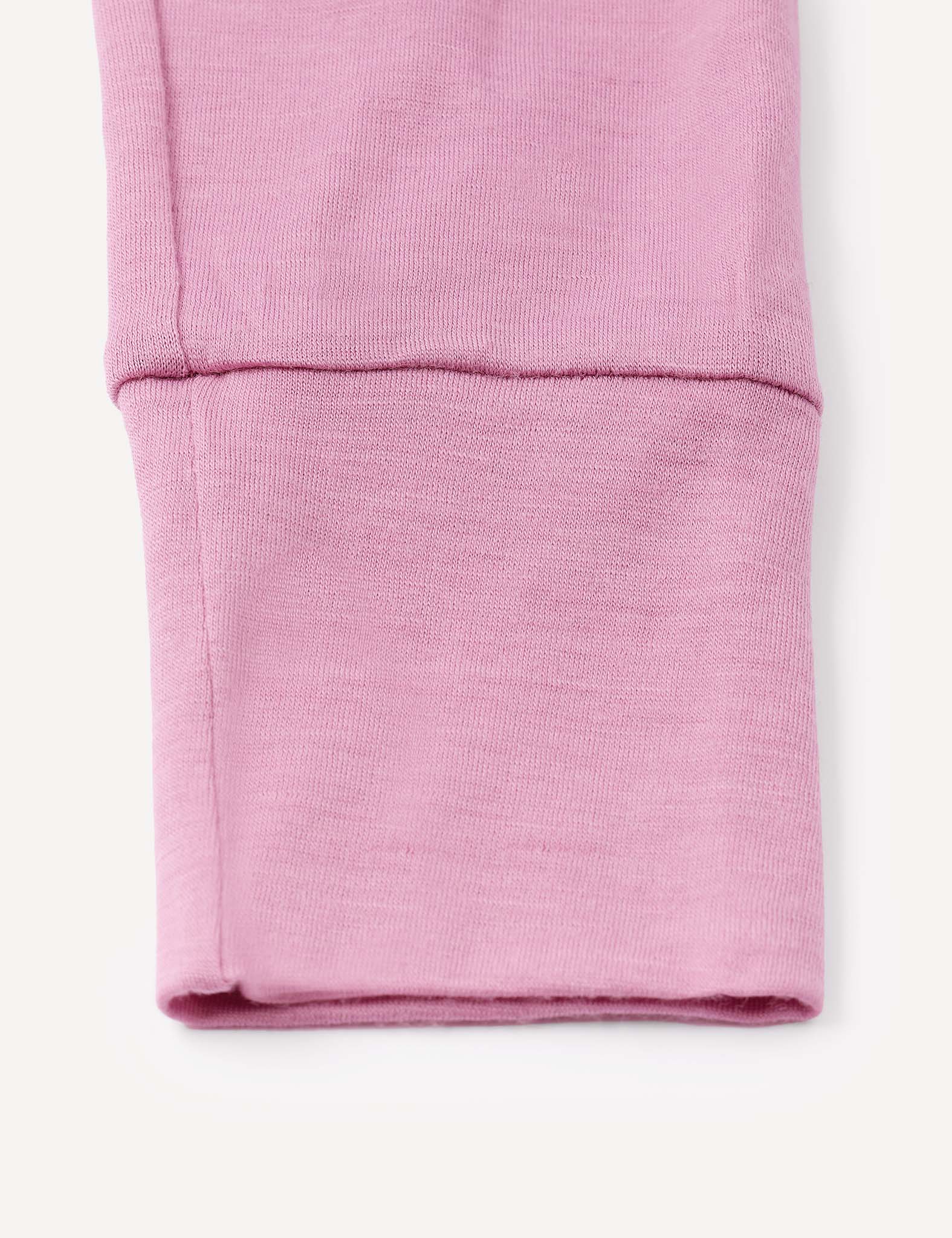 Close-up of a pink, folded sleeve from the Pyjamas – Merino Baby Light, showing detailed stitching and texture on a light background, highlighting the breathable merino material.