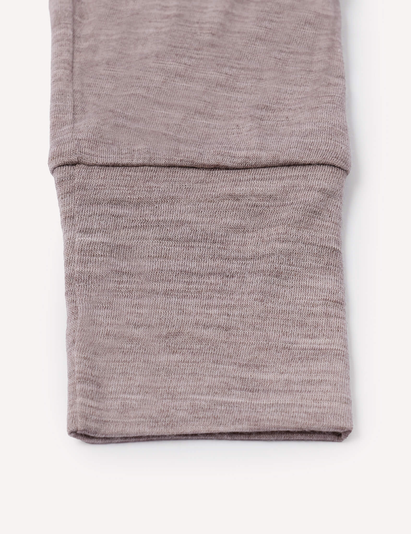 Close-up of a folded sleeve from the Pyjamas – Merino Baby Light, crafted in light brown, heathered merino wool and displayed on a plain white background—an ideal detail for those seeking breathable sleepwear.