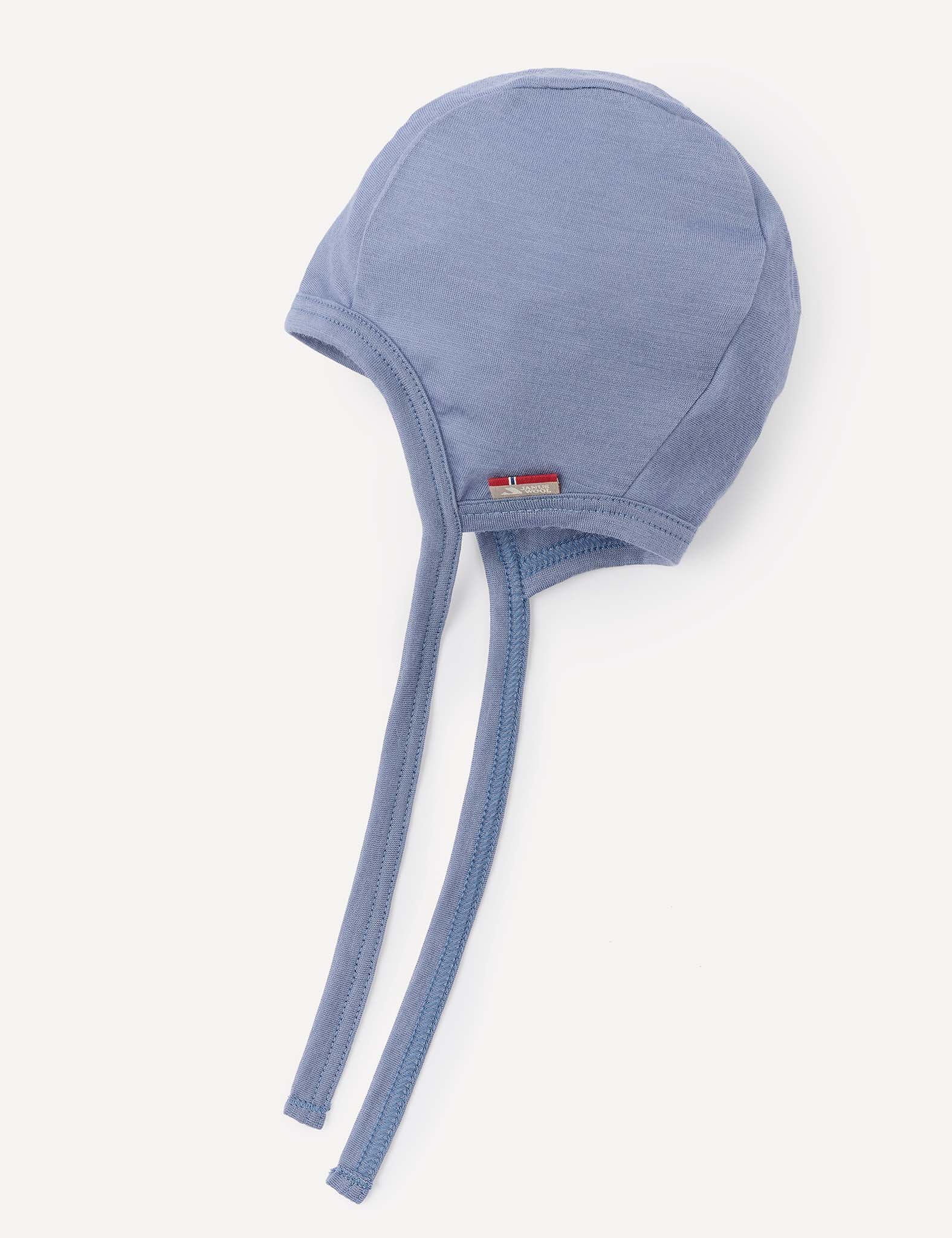 A Bonnet – Merino Baby Light in the color Troposphere, made from lightweight merino wool and featuring two long chin straps with a small flag tag on the front, displayed on a white background. This stylish and practical bonnet is perfect for your baby.