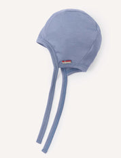 A Bonnet – Merino Baby Light in the color Troposphere, made from lightweight merino wool and featuring two long chin straps with a small flag tag on the front, displayed on a white background. This stylish and practical bonnet is perfect for your baby.