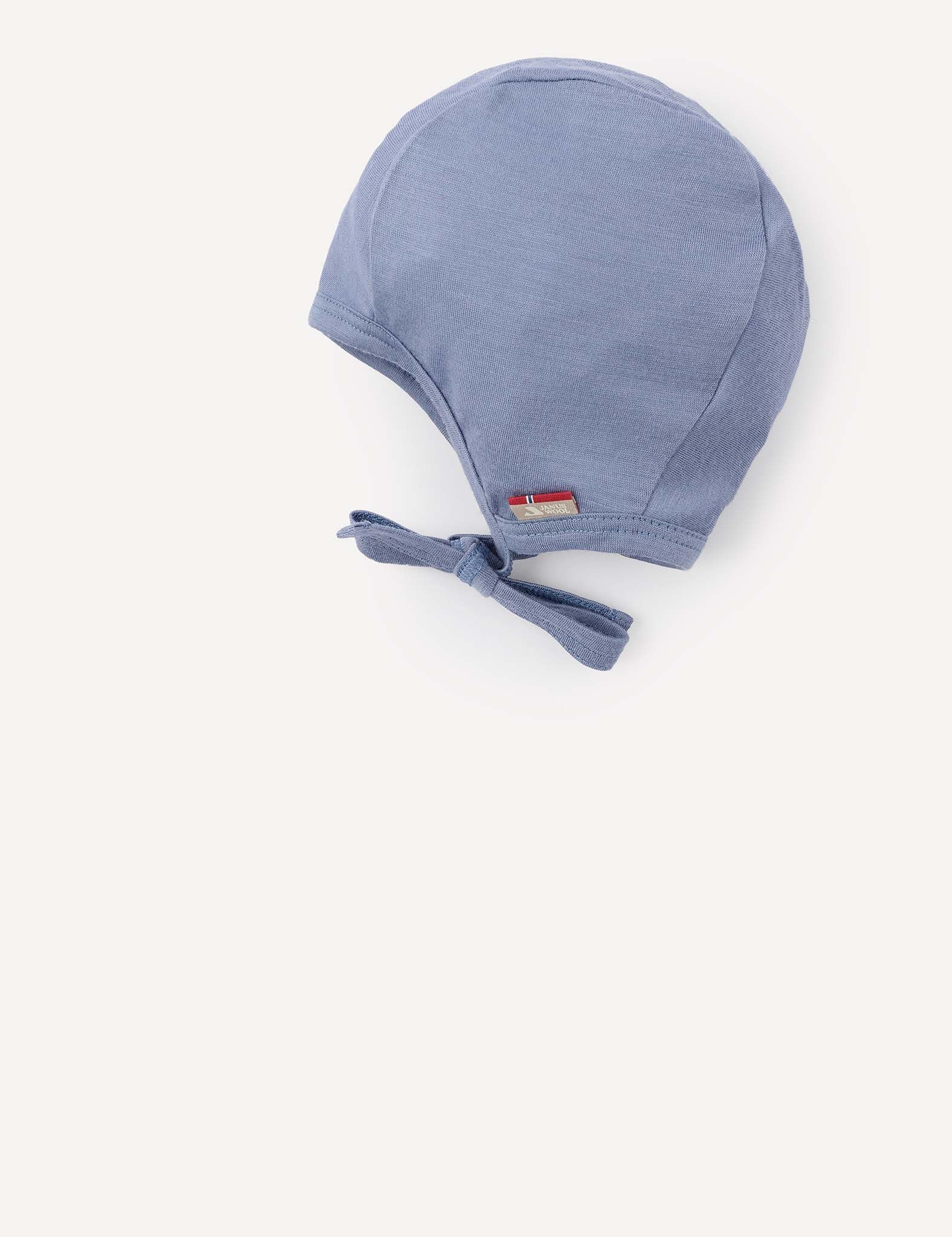 A light blue “Bonnet – Merino Baby Light,” featuring a breathable design, a small fabric Norwegian flag tag, and a bow tie at the chin, displayed on a plain white background.