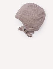 The Bonnet – Merino Baby Light is a light brown, textured merino wool bonnet featuring a lightweight tie under the chin, displayed against a plain white background.