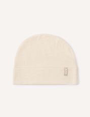 A Beanie – Merino Baby Light in the color Marshmallow, featuring a folded brim and a small fabric tag on the side, is displayed on a light background.