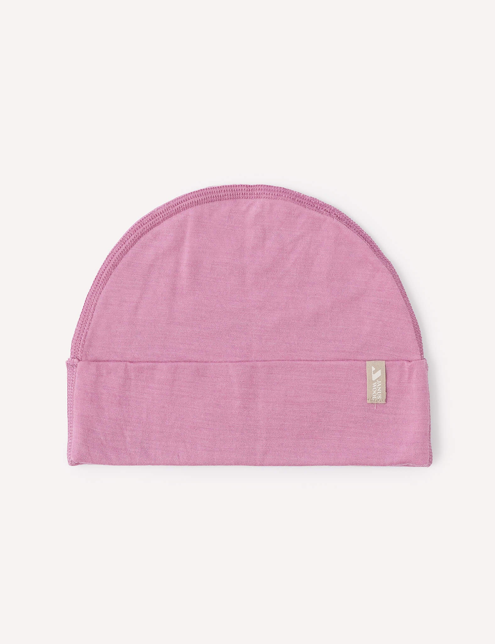 A mauve orchid, semi-circular lightweight Merino baby beanie with a folded brim and a small rectangular tag on the right side, displayed on a plain light background.