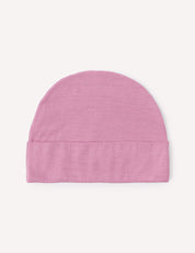 A lightweight Merino Baby Light Beanie in light pink, featuring a simple design with a folded brim, is laid flat on a plain white background.