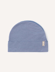 A lightweight “Beanie – Merino Baby Light” in Troposphere blue knit, featuring a folded brim and a small rectangular beige tag on the side, displayed against a plain off-white background.