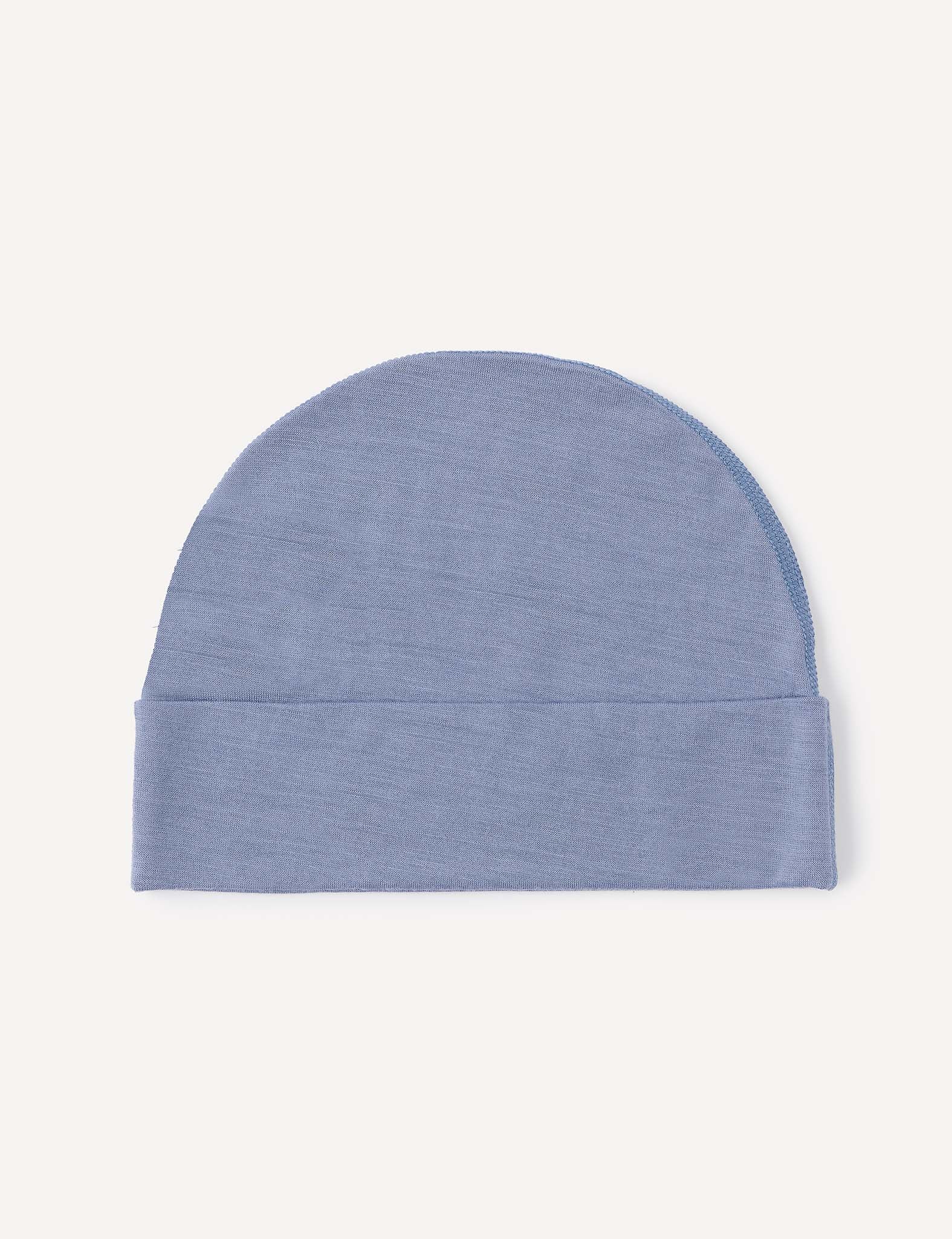 A light blue Beanie – Merino Baby Light, crafted from ultra-soft merino wool, is laid flat on a plain white background. This lightweight baby beanie features a simple, seamless design and a folded brim at the bottom, offering breathable comfort for everyday wear.