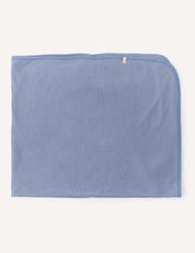 A Blanket – Merino Baby Light in light blue, lightweight and neatly folded with a small beige tag on one edge, displayed on a plain off-white background.