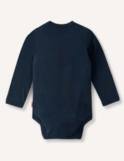 The Body – Merino Baby Light is a long-sleeved, dark blue merino wool bodysuit for babies, shown from the back against a plain light background. This breathable garment combines comfort and style for your little one.