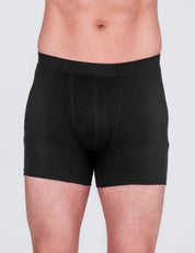 A person wearing the Boxers – Classic Merino 160 Men in black is shown from waist to mid-thigh against a plain light background. Their upper body and face are not visible.