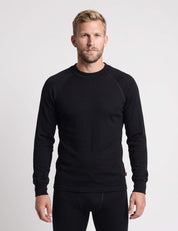 A man wearing a black Wool Set – Classic Merino 200 Rib Men long-sleeved crew-neck shirt and matching base layer bottoms.