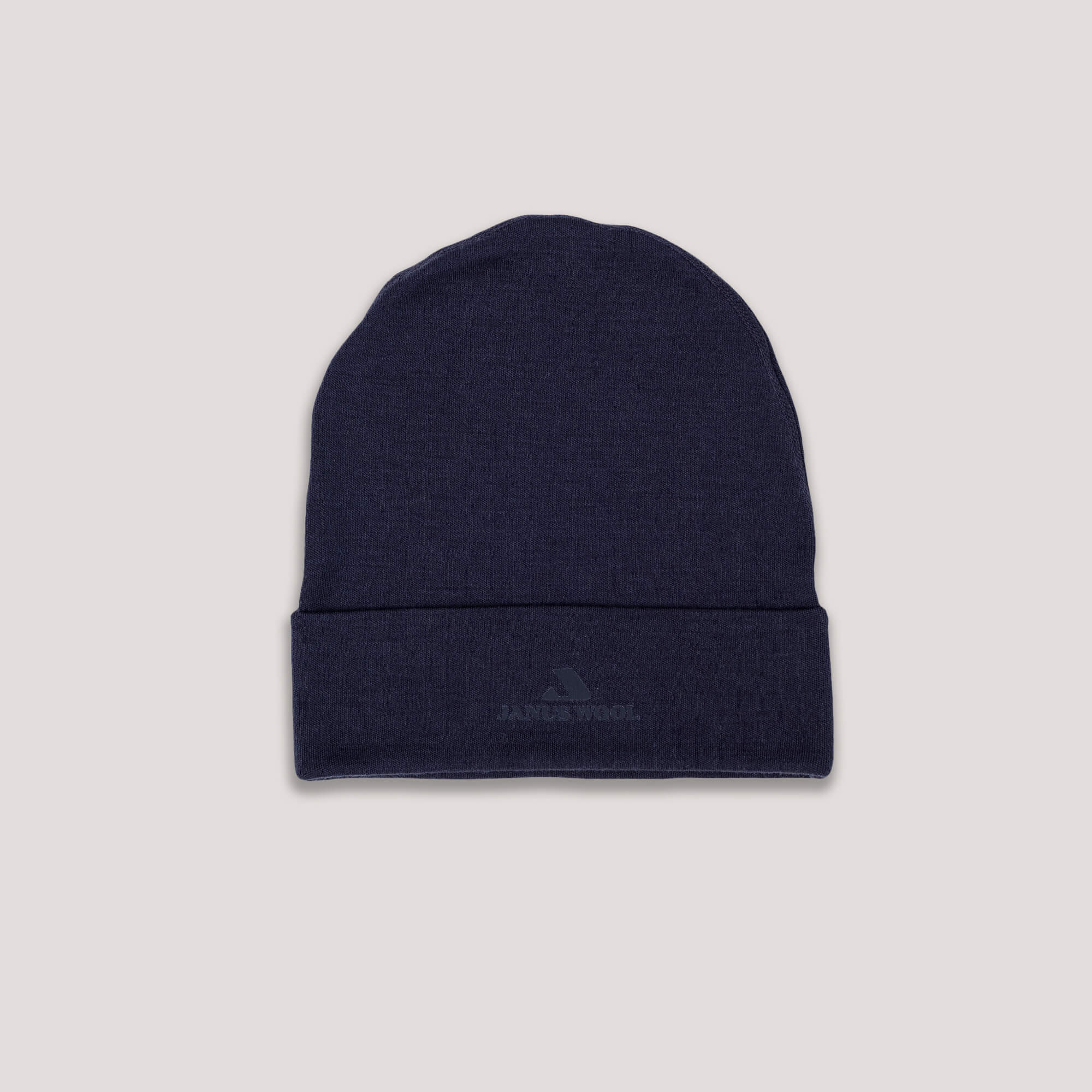 The Beanie – Classic Merino 215 in navy features a folded brim and a subtle front logo, offering warmth and breathability. Displayed against a light gray background.