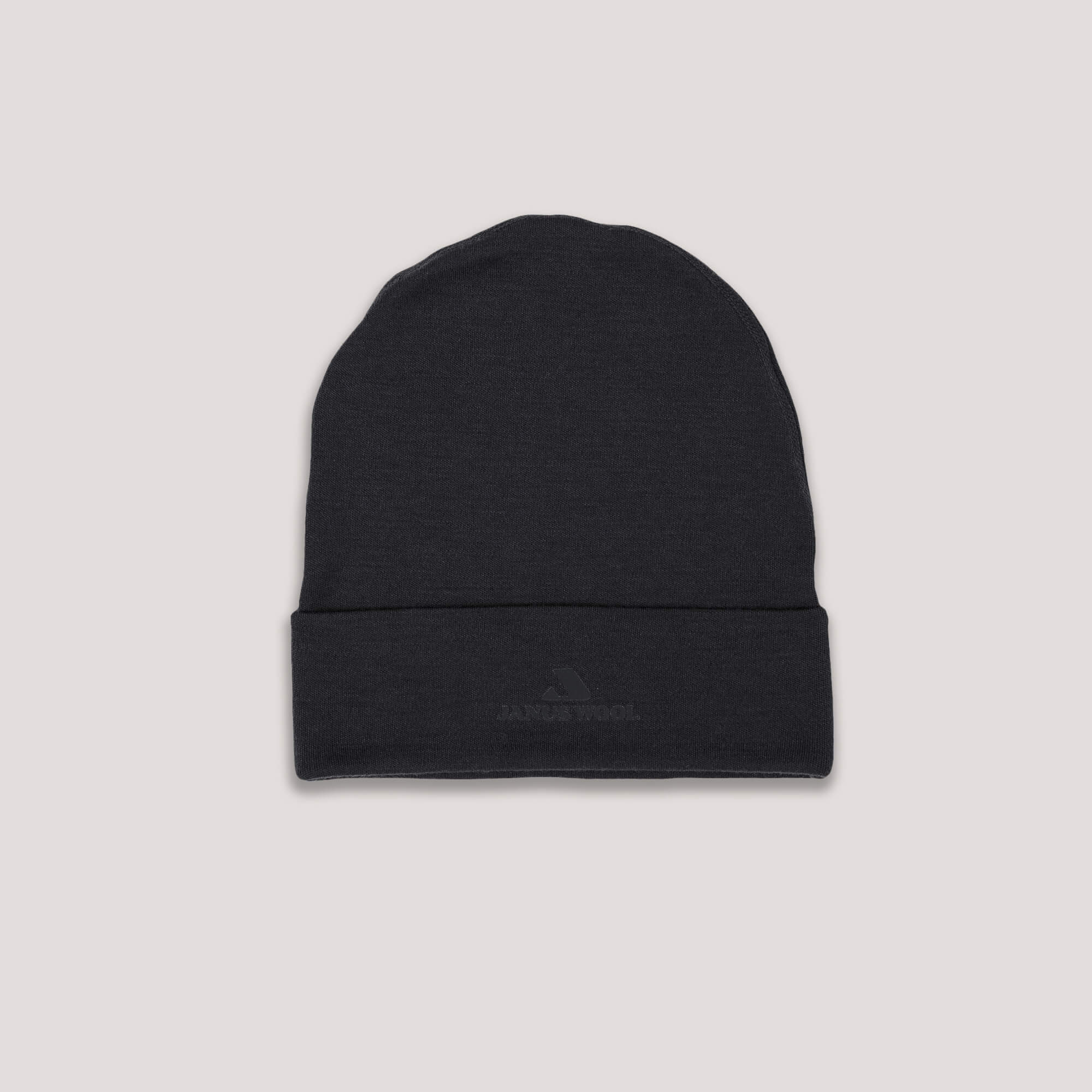 The Beanie – Classic Merino 215 in black, shown on a light gray background, features a folded brim and subtle logo. Made from merino wool, it offers superior warmth and breathability.
