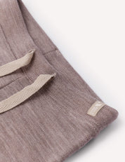 Close-up of brushed Pants – Merino Baby AirWool trousers featuring a beige adjustable drawcord and a small beige tag sewn near the seam, highlighting subtle stitch details and the soft texture against a white background.