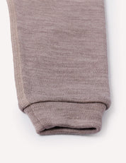 A close-up of the cuff of a light brown Merino Baby AirWool knit pant leg, highlighting the texture and stitching detail against a plain white background.