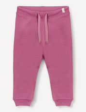 Merino Baby AirWool Pants in pink, featuring an adjustable drawcord waistband and ribbed cuffs, crafted from soft brushed AirWool, displayed on a plain white background.