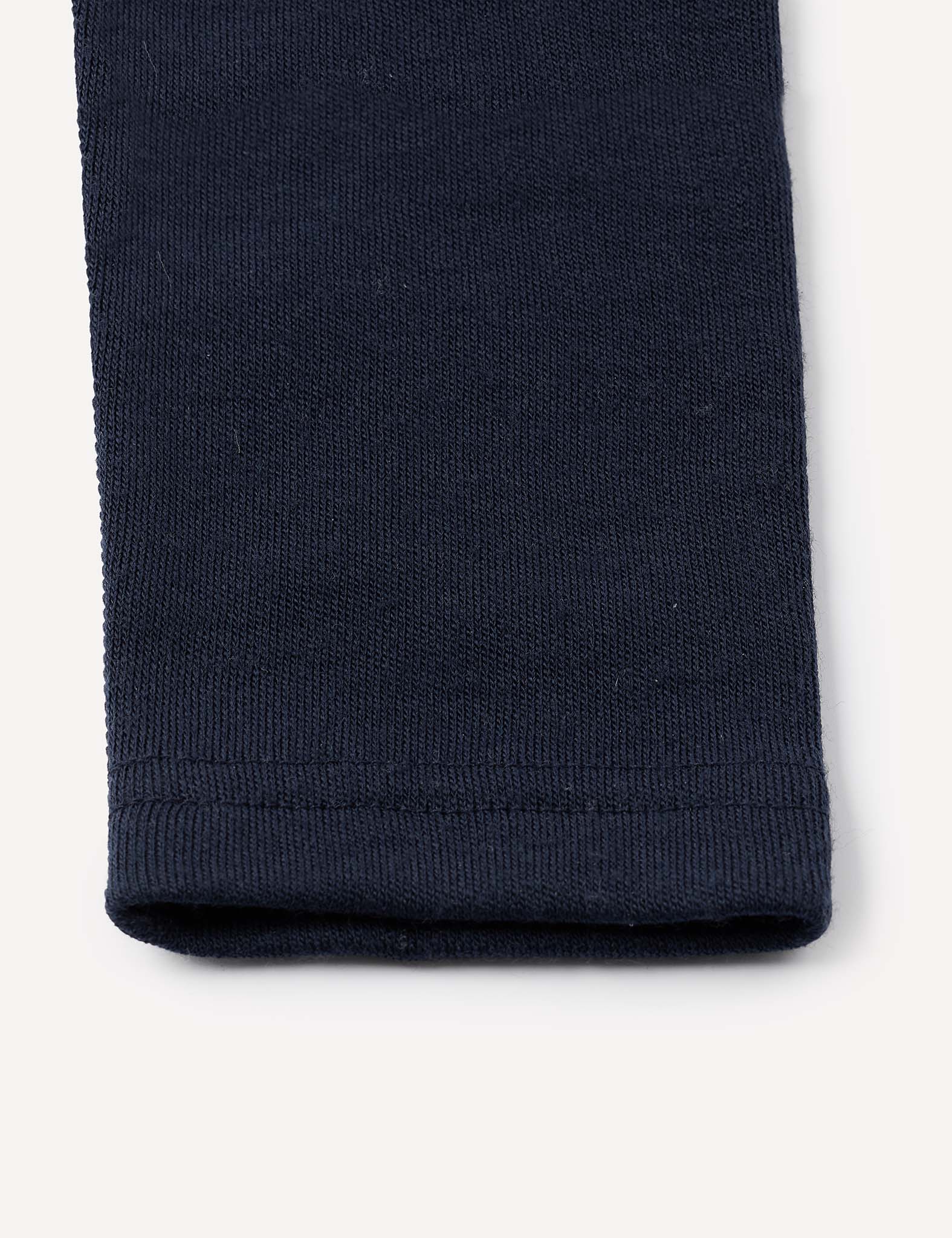 Close-up of the hem of a navy blue Leggings – Merino Baby AirWool, showcasing the fabric’s texture and stitching details against a plain light background.