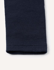 Close-up of the hem of a navy blue Leggings – Merino Baby AirWool, showcasing the fabric’s texture and stitching details against a plain light background.