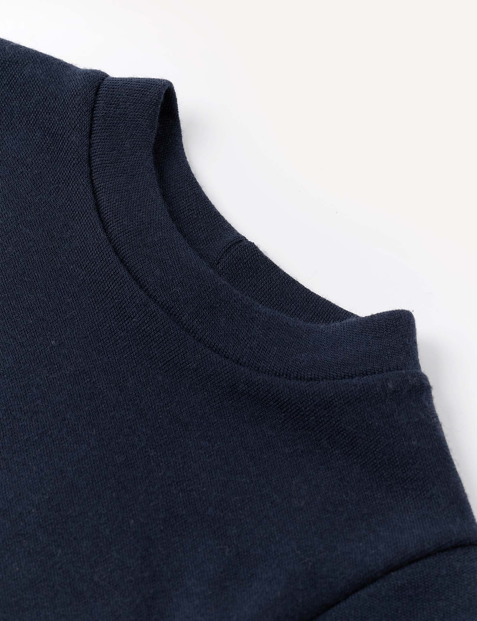 Close-up of the neckline and shoulder of the Pullover – Merino Baby AirWool in navy blue, displayed against a light background. The fabric looks thick and soft, providing breathable insulation.