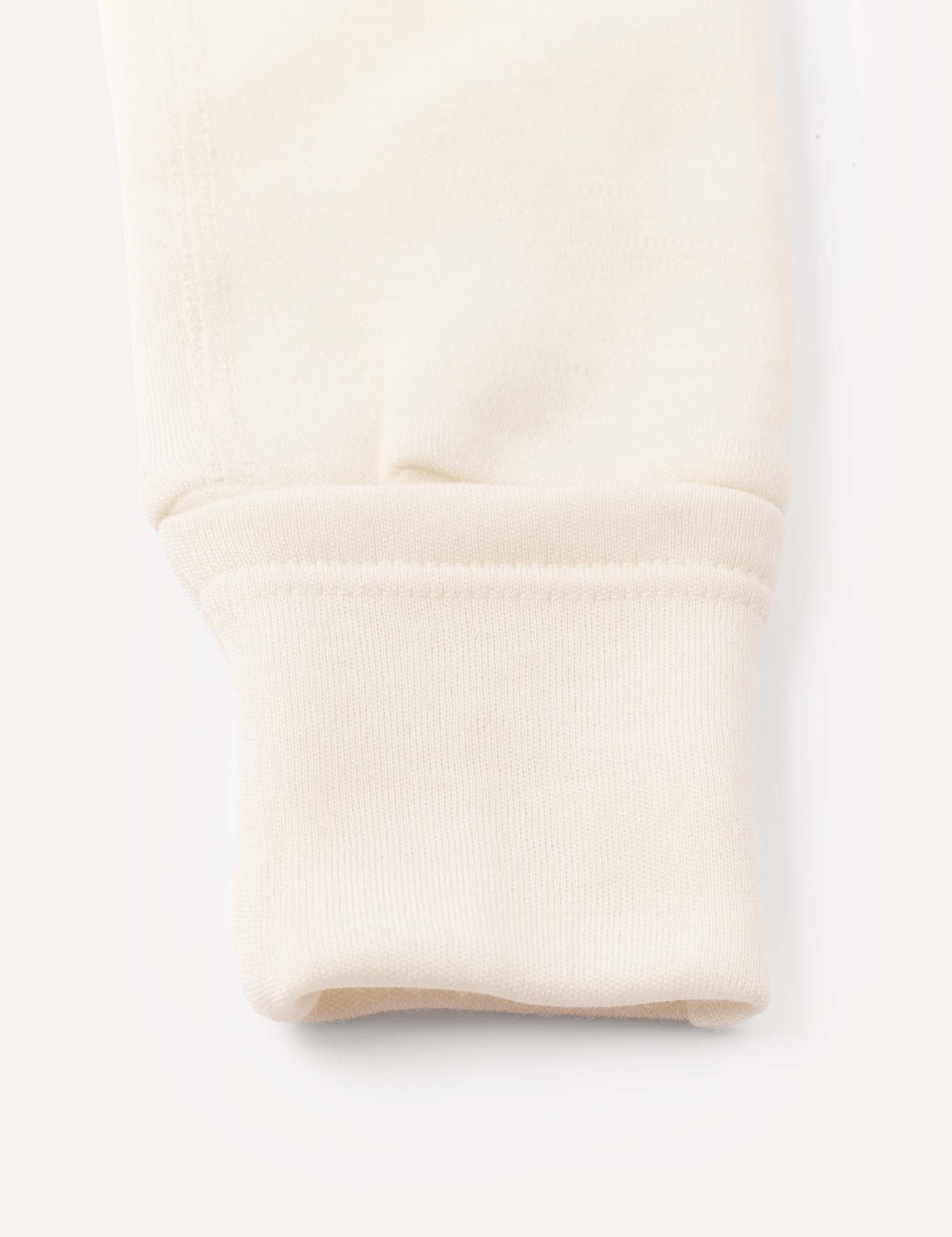 Close-up of the sleeve cuff on the Onesie – Merino Baby AirWool, highlighting the fold-over design and ribbed fabric at the end, along with smooth stitching details.