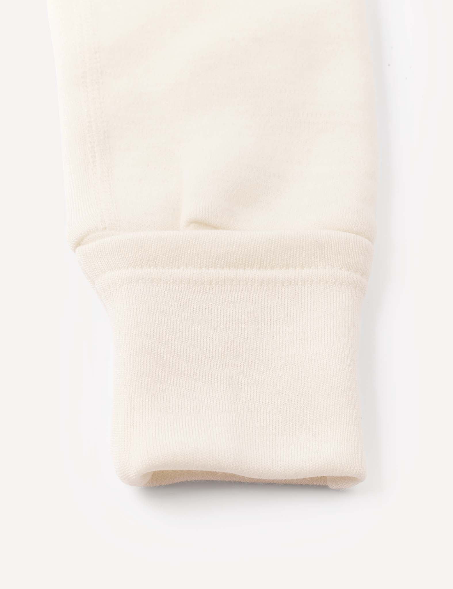 Close-up of the sleeve cuff on the Onesie – Merino Baby AirWool, highlighting the fold-over design and ribbed fabric at the end, along with smooth stitching details.