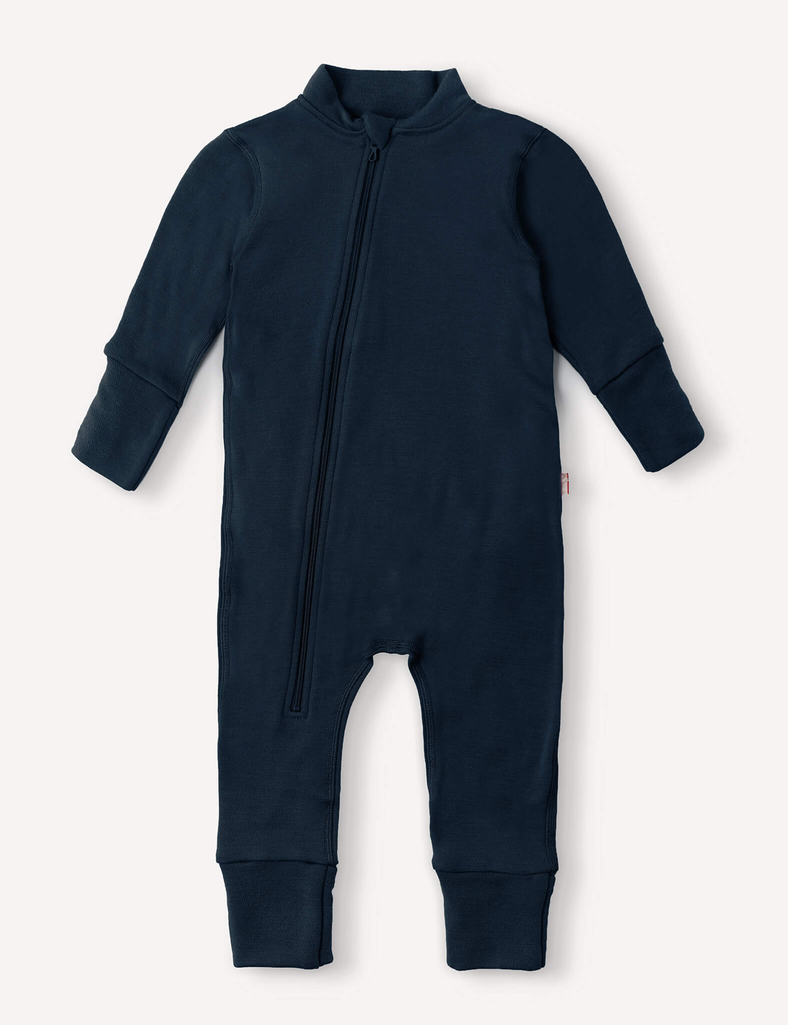 Introducing the Onesie – Merino Baby AirWool in navy, a long-sleeved, full-length suit crafted from breathable merino wool for optimal insulation. Featuring a diagonal front zipper from neck to leg and fold-over cuffs for extra comfort.