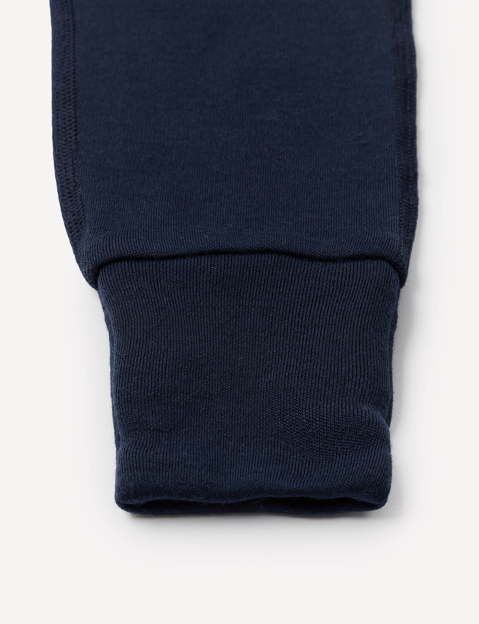 A close-up of the cuff of a Onesie – Merino Baby AirWool, showing ribbed, fold-over cuffs at the ankle.