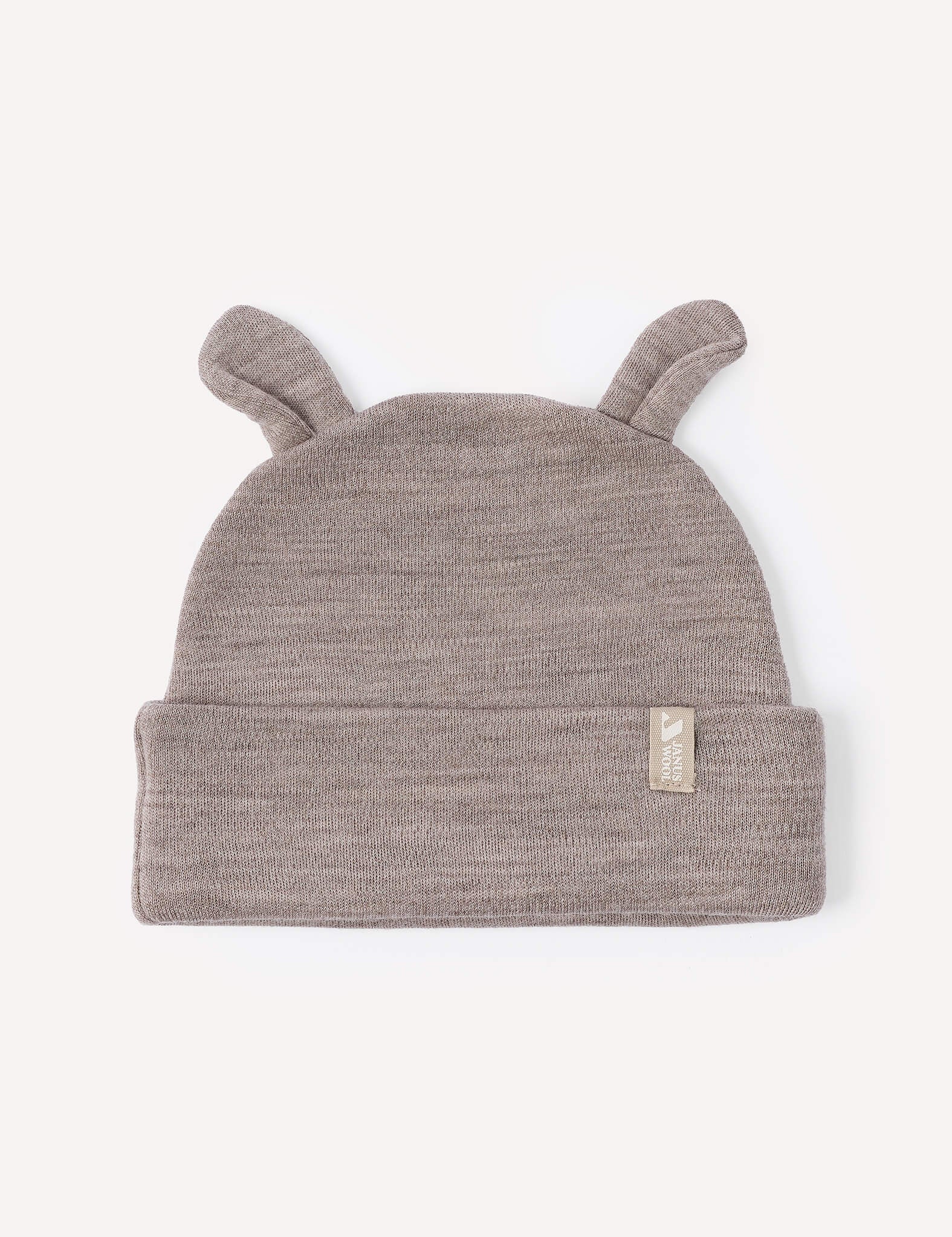 A beige melange merino wool baby beanie, the Beanie – Merino Baby AirWool, features two small ear-like points on top and a folded brim with a small beige fabric tag on the front. This warm hat offers cozy comfort for your little one.