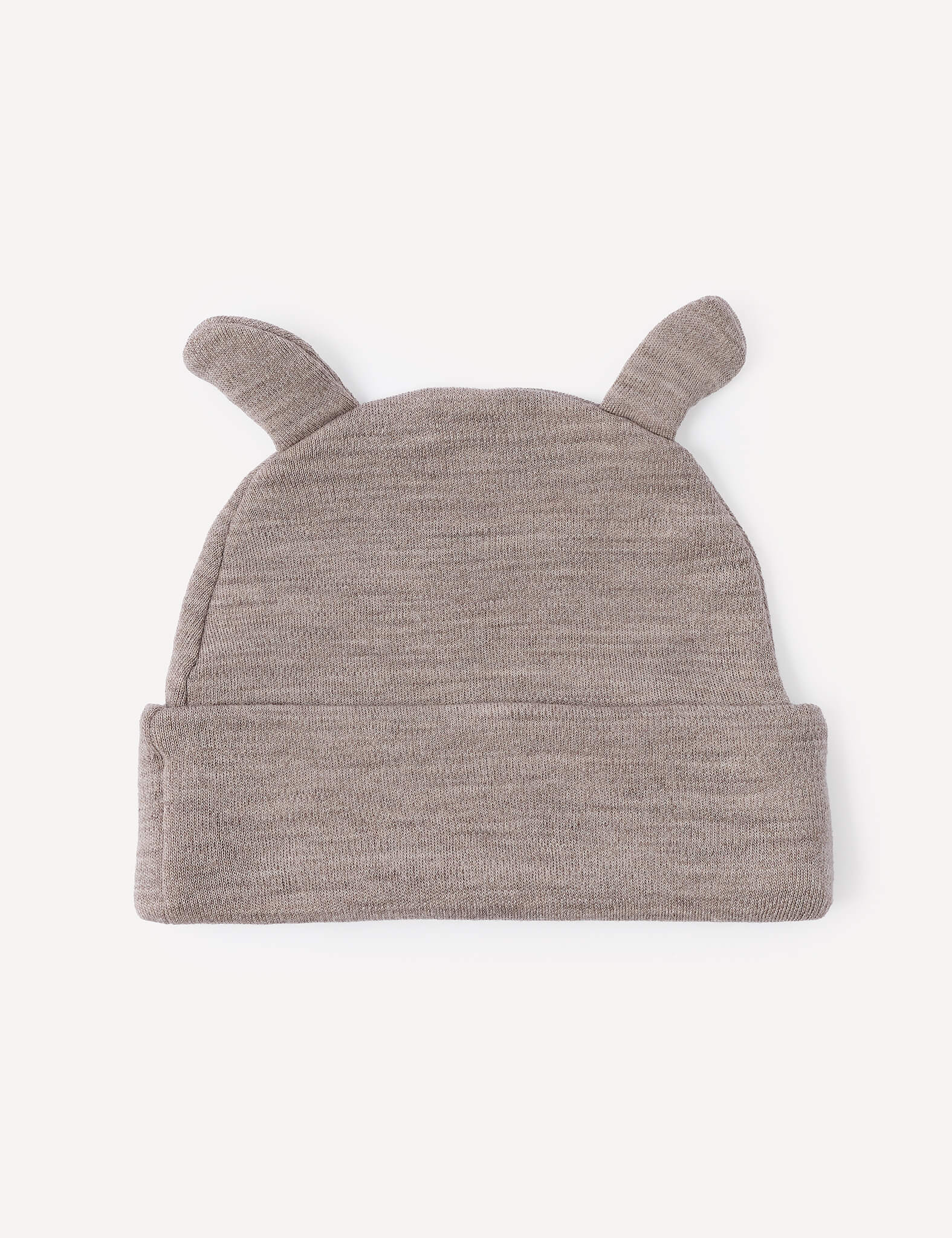 The Beanie – Merino Baby AirWool is a soft, light brown knit baby beanie crafted from gentle AirWool, featuring two small, rounded ear-like protrusions on top and shown laid flat on a light background.