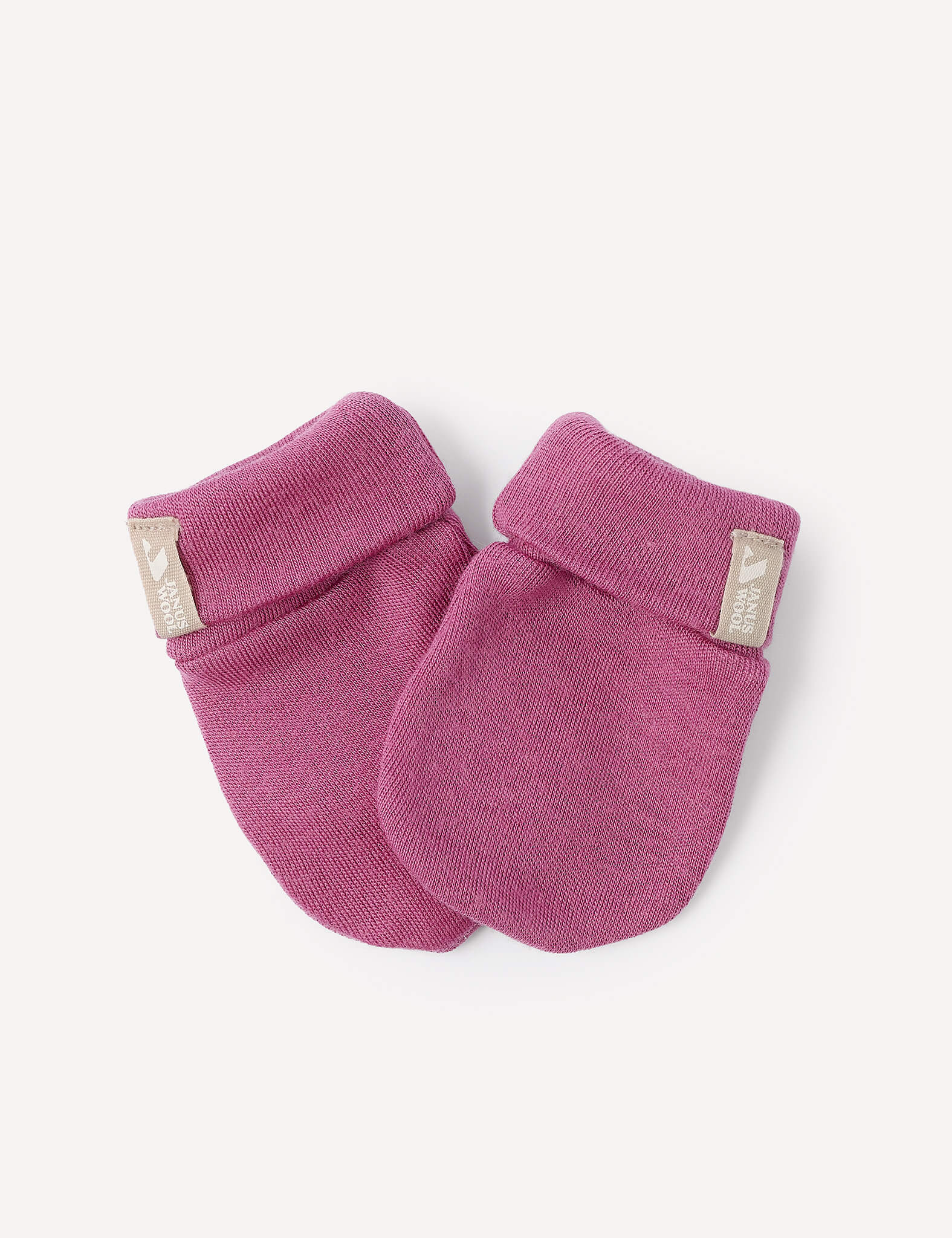 A pair of Mittens – Merino Baby AirWool, crafted from cozy merino wool in a soft pink shade, featuring folded cuffs and a small fabric tag on each cuff, displayed against a plain white background.