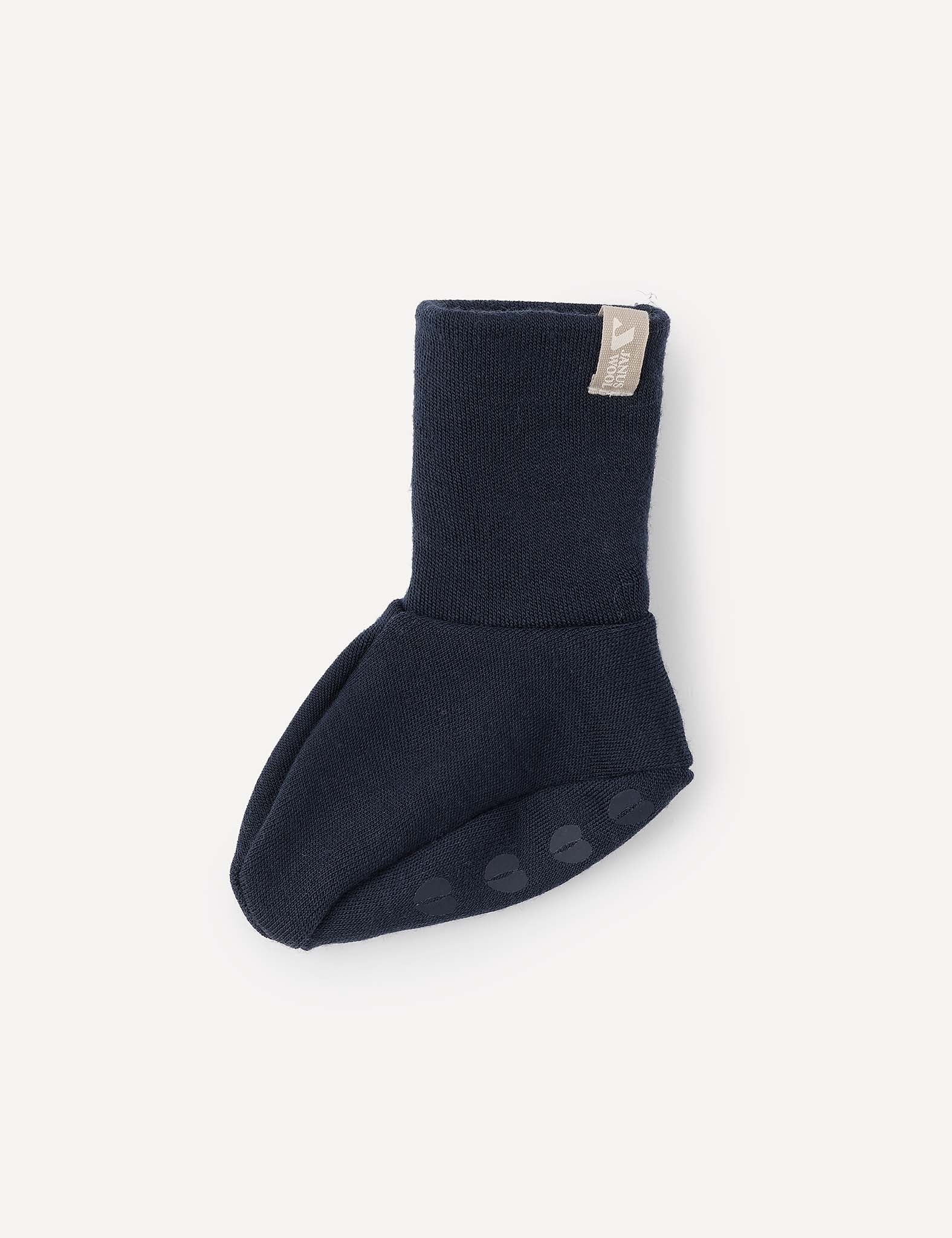 A single Booties – Merino Baby AirWool in dark navy, featuring a folded cuff and non-slip sole grips, is displayed on a light background—these breathable baby booties are designed to keep little feet comfortable.