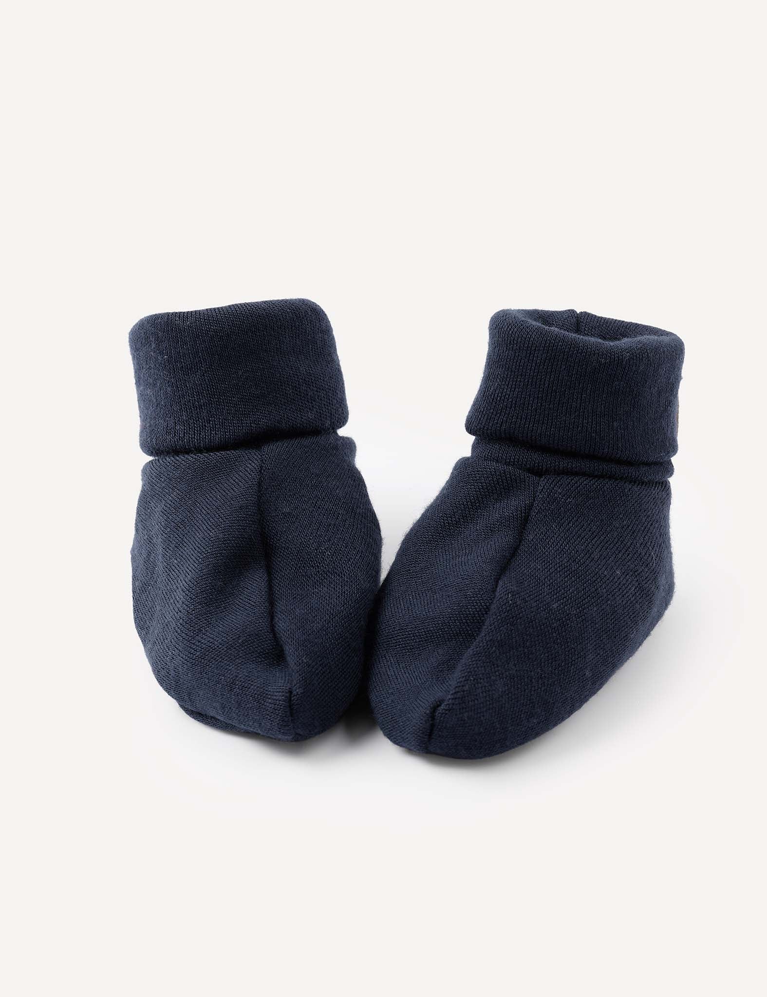 A pair of Booties – Merino Baby AirWool in navy, with folded cuffs, are placed side by side on a light background.