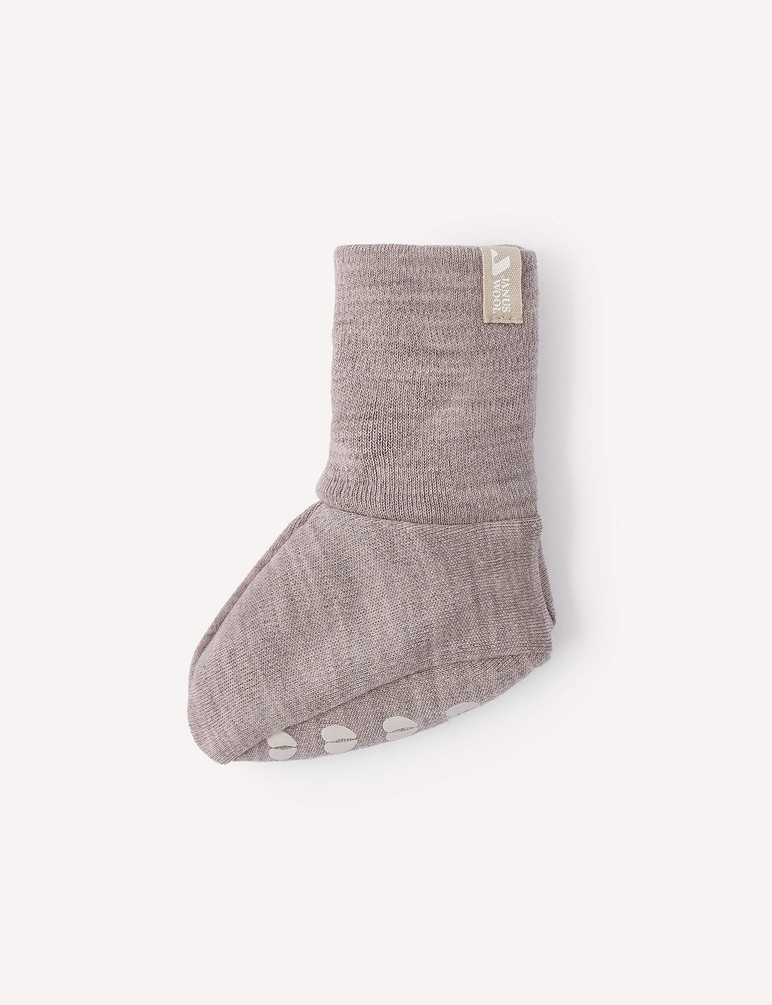 A single Booties – Merino Baby AirWool in light brown, featuring a folded cuff and non-slip white grips on the sole, displayed against a plain white background.