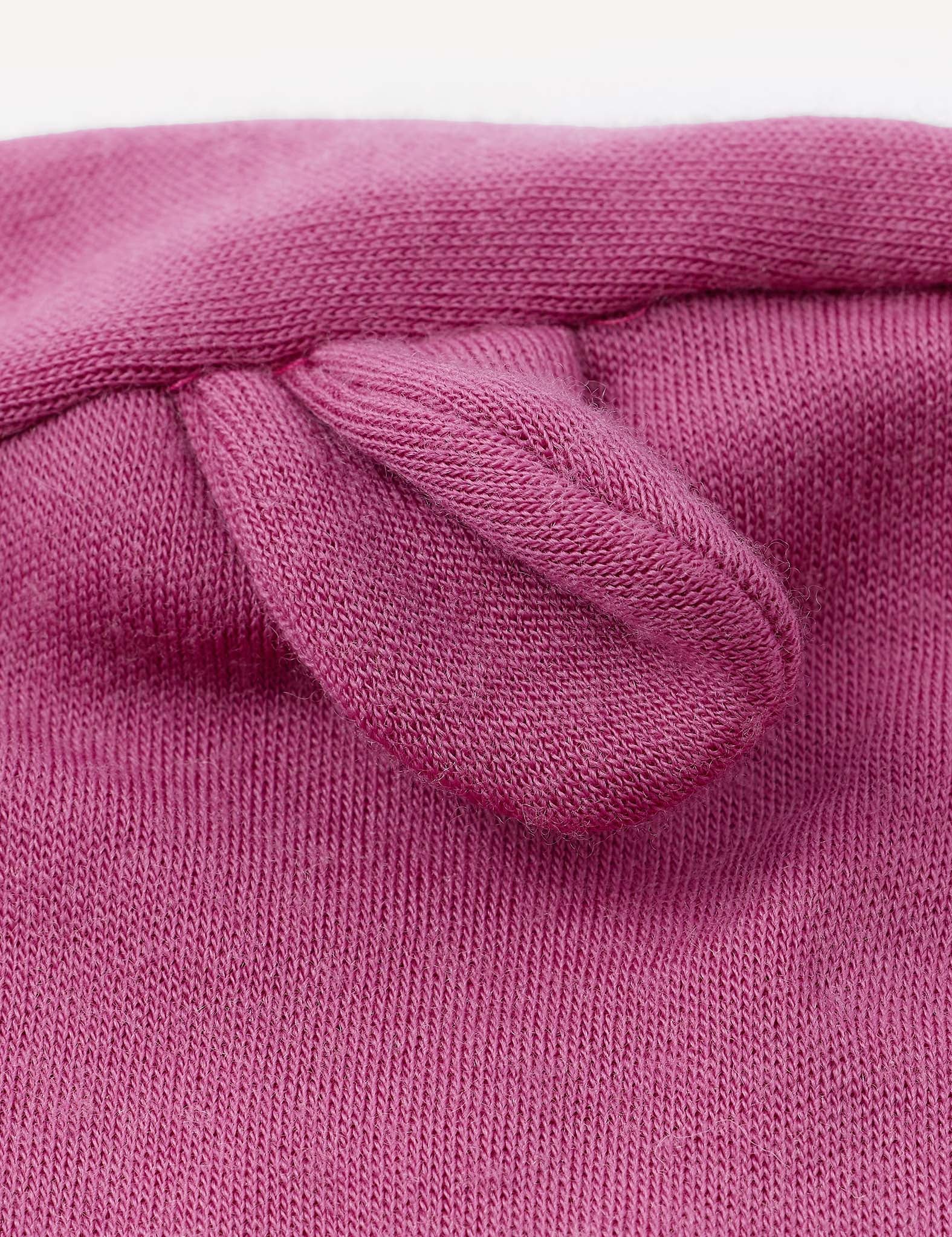 Close-up of the pink Balaclava – Merino Baby AirWool, showing a small, rounded fabric ear or knob sewn onto its knitted fabric—suggesting its breathable and comfortable design.